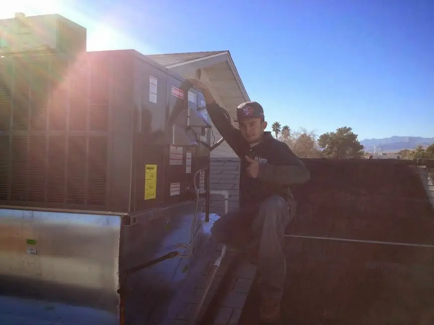 HVAC technician performing AC Tune-Up on a rooftop unit in Long Beach